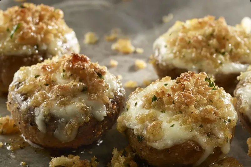 Stuffed mushrooms topped with melted white cheddar and breadcrumbs (illustrative image)