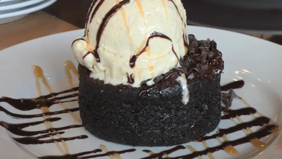 Molten Lava Cake: warm chocolate cake topped with vanilla ice cream and chocolate drizzle (illustrative image)