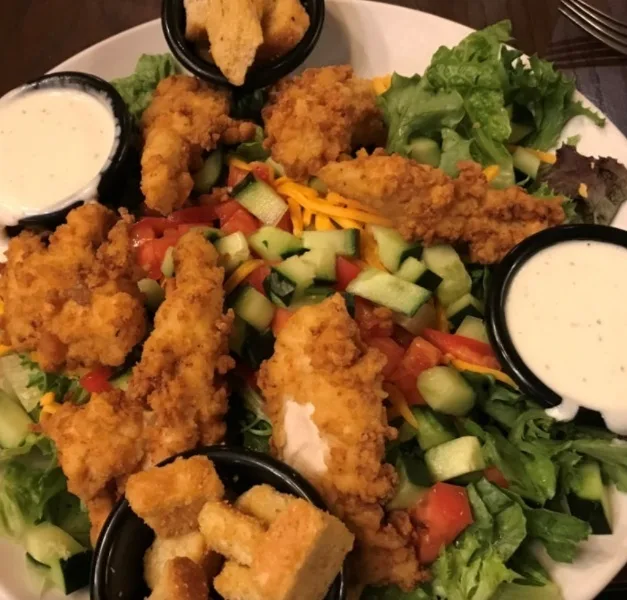 Field greens salad with crispy chicken tenders (illustrative image)