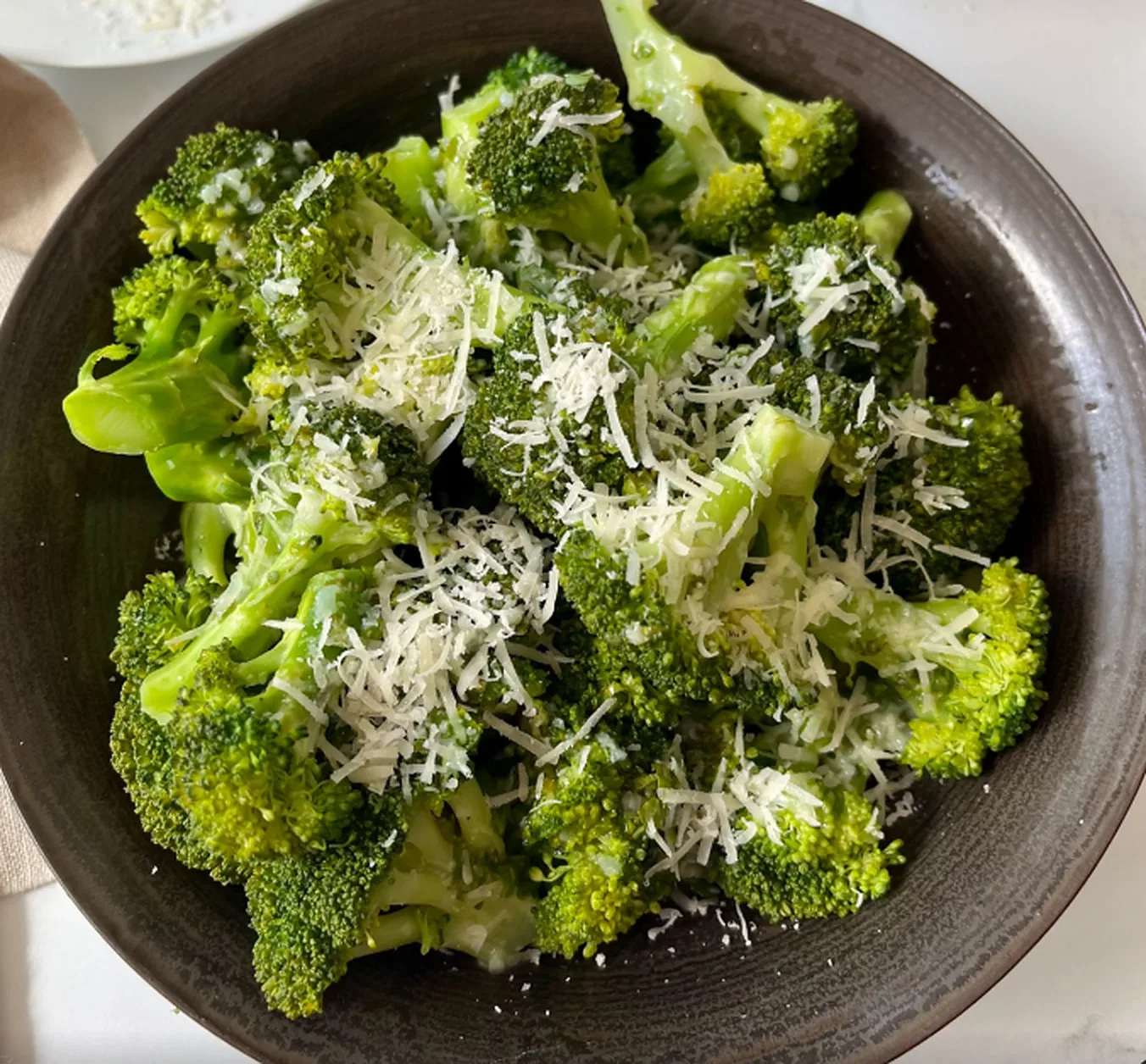 Steamed broccoli topped with grated parmesan (illustrative image)