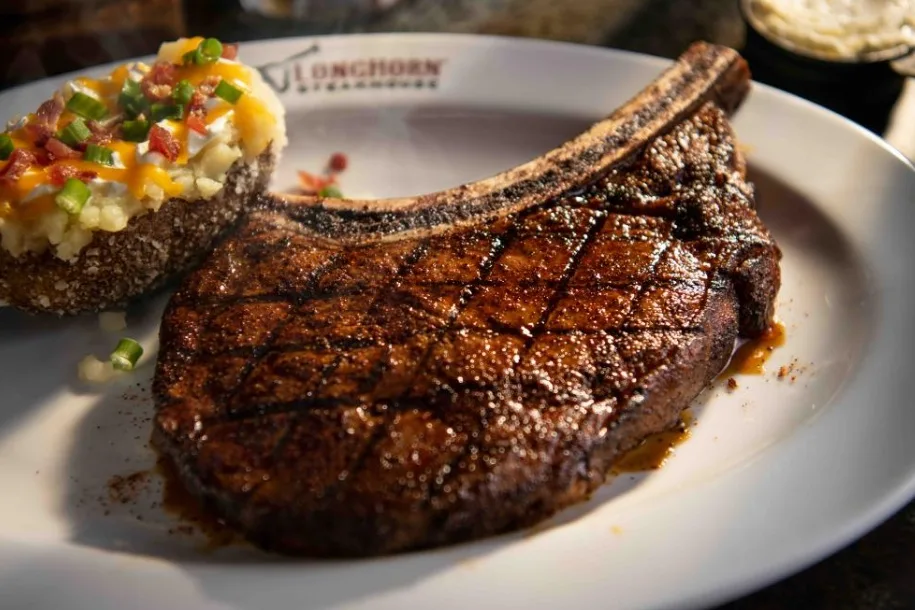 Bone-in Outlaw Ribeye with a loaded baked potato (illustrative image)