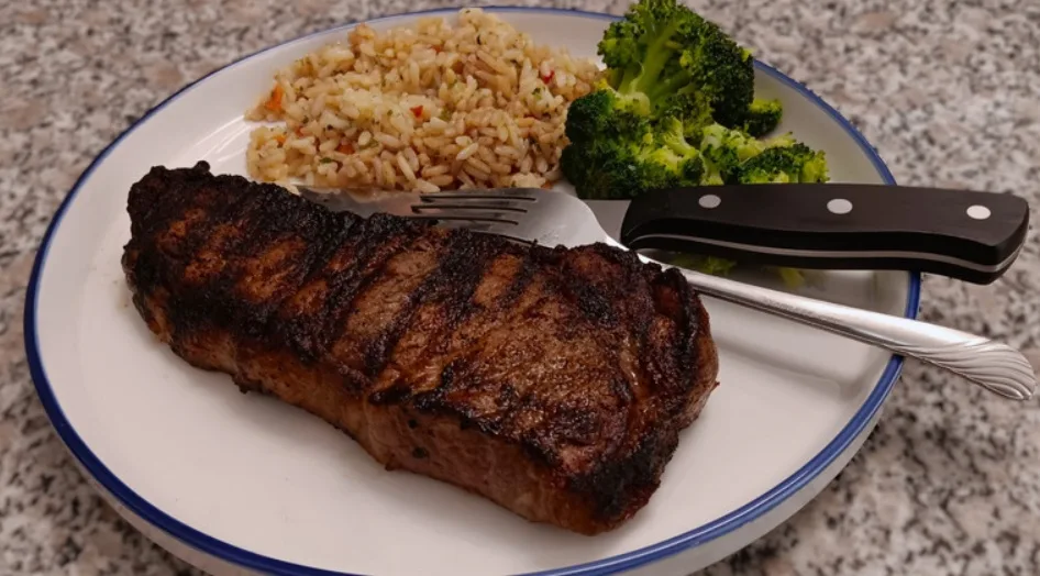 Grilled strip steak with rice pilaf and steamed broccoli (illustrative image)